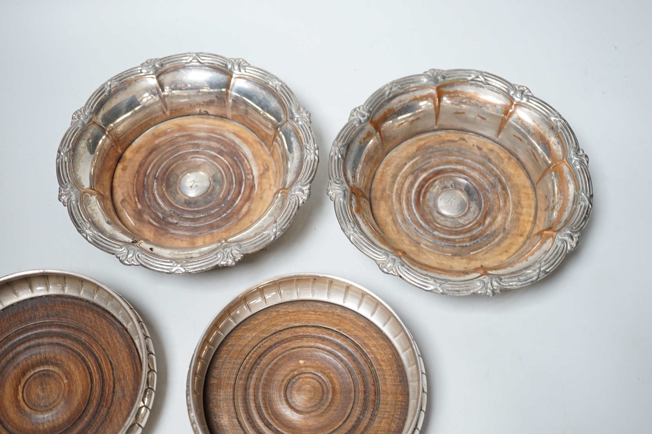 A pair of Elizabeth II silver wine coasters, London, 1973, diameter 13.4cm and a plated pair of wine coasters.